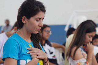 Pessoa em oração, representando o dom do discernimento dos espíritos.