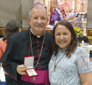 Dom Mário Antonio, arcebispo de Aparecida, sorrindo ao lado de Patrícia Holanda, missionária da Comunidade Shalom, durante a cerimônia de posse no Santuário Nacional.